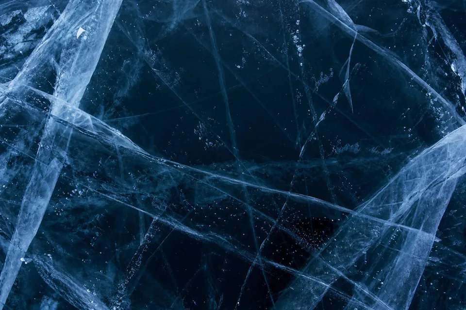 Cracked blue lake ice lit from beneath