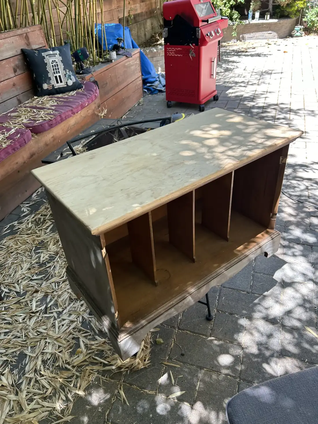 The same cabinet stripped to its carcass outdoors, with a new top being fitted