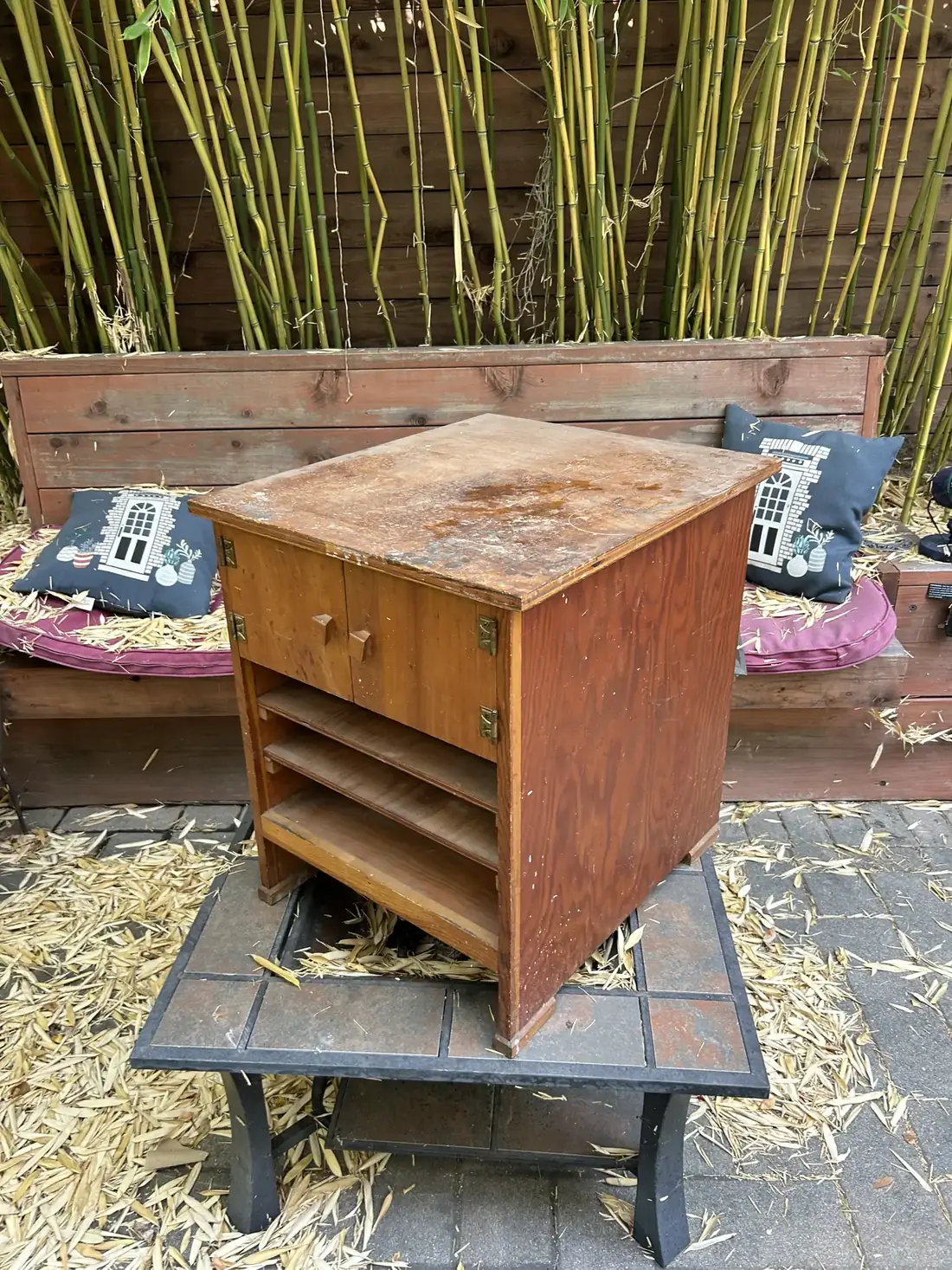 A small orange-brown side cabinet with a water-damaged top